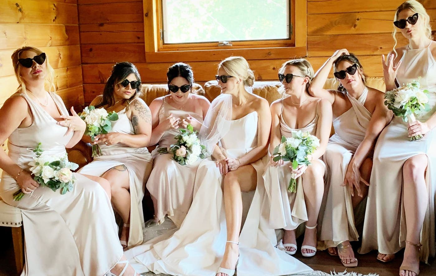 The bridal party in matching robes and sunglasses, mid-celebration.